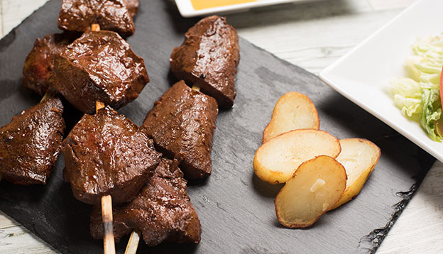 Anticuchos - grilled skewered beef heart meat with boiled potato and white corn